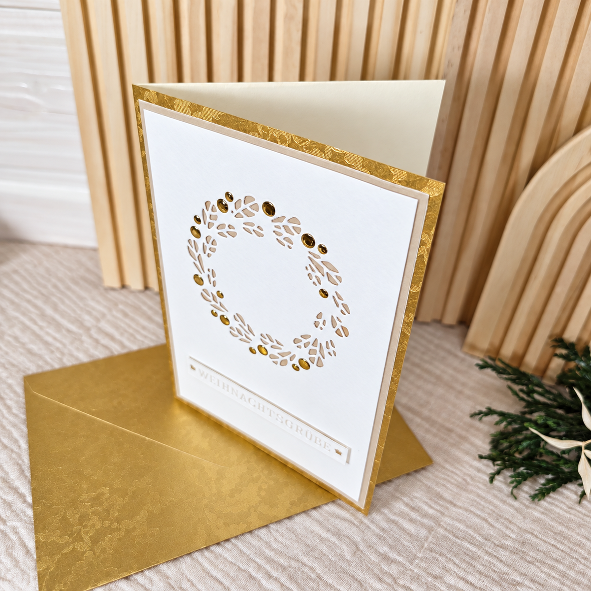 Seitliche Ansicht der aufgeklappten Weihnachtskarte mit mehrlagiger weißer Vorderseite und goldenem Rand