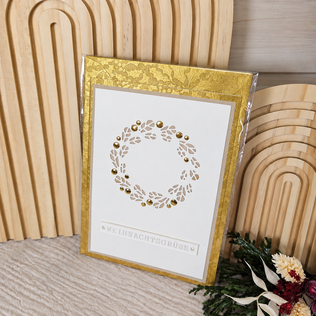 Weihnachtskarte mit goldfarbenem Umschlag in einer transparenten Schutzhülle