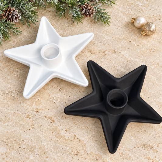 Sternkerzenhalter in Weiß und Schwarz auf hellem Untergrund mit dezenter Weihnachtsdekoration.