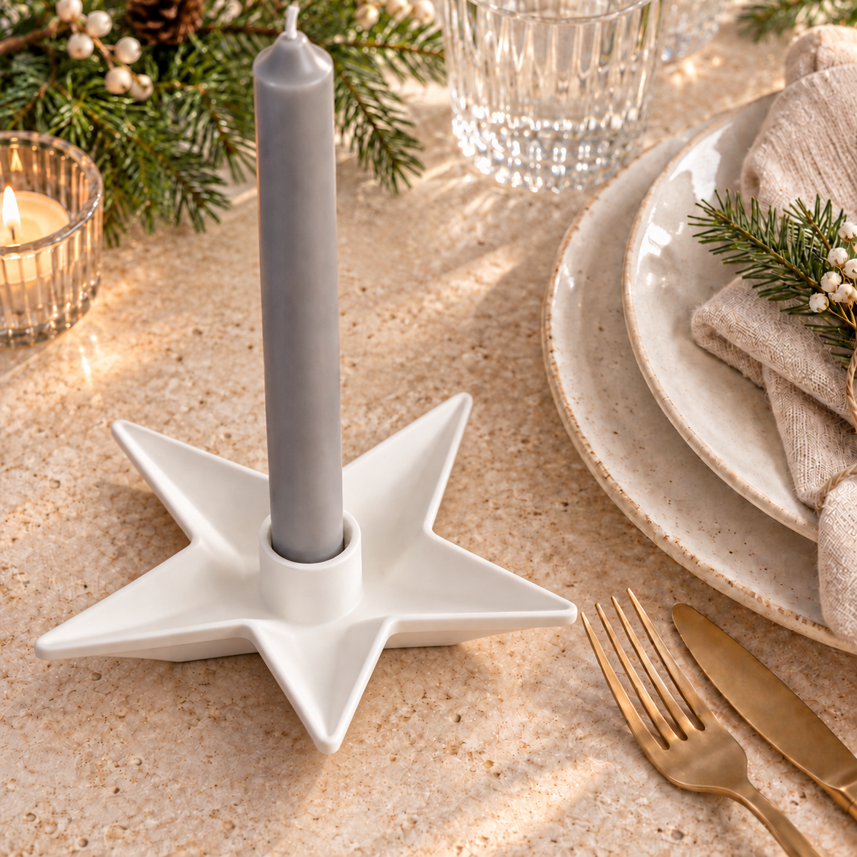 Weißer Sternkerzenhalter mit grauer Stabkerze auf einem festlich gedeckten Adventstisch.