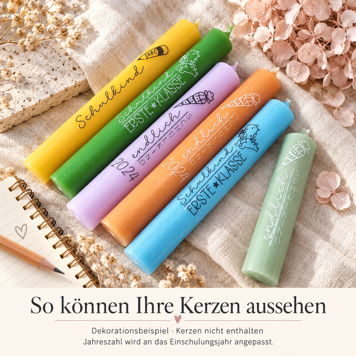 Sechs farbige Kerzen mit Schulkind-Schriftzügen, Dinosauriern und Schultüten auf hellem Stoff als Gestaltungsbeispiel. Kerzen nicht enthalten.