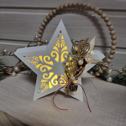 Beleuchteter Dekostern mit Trockenblumen und Glöckchen als Weihnachtsdekoration