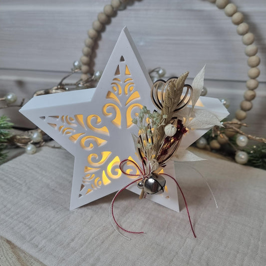 Beleuchteter Dekostern mit Trockenblumen und Glöckchen als Weihnachtsdekoration